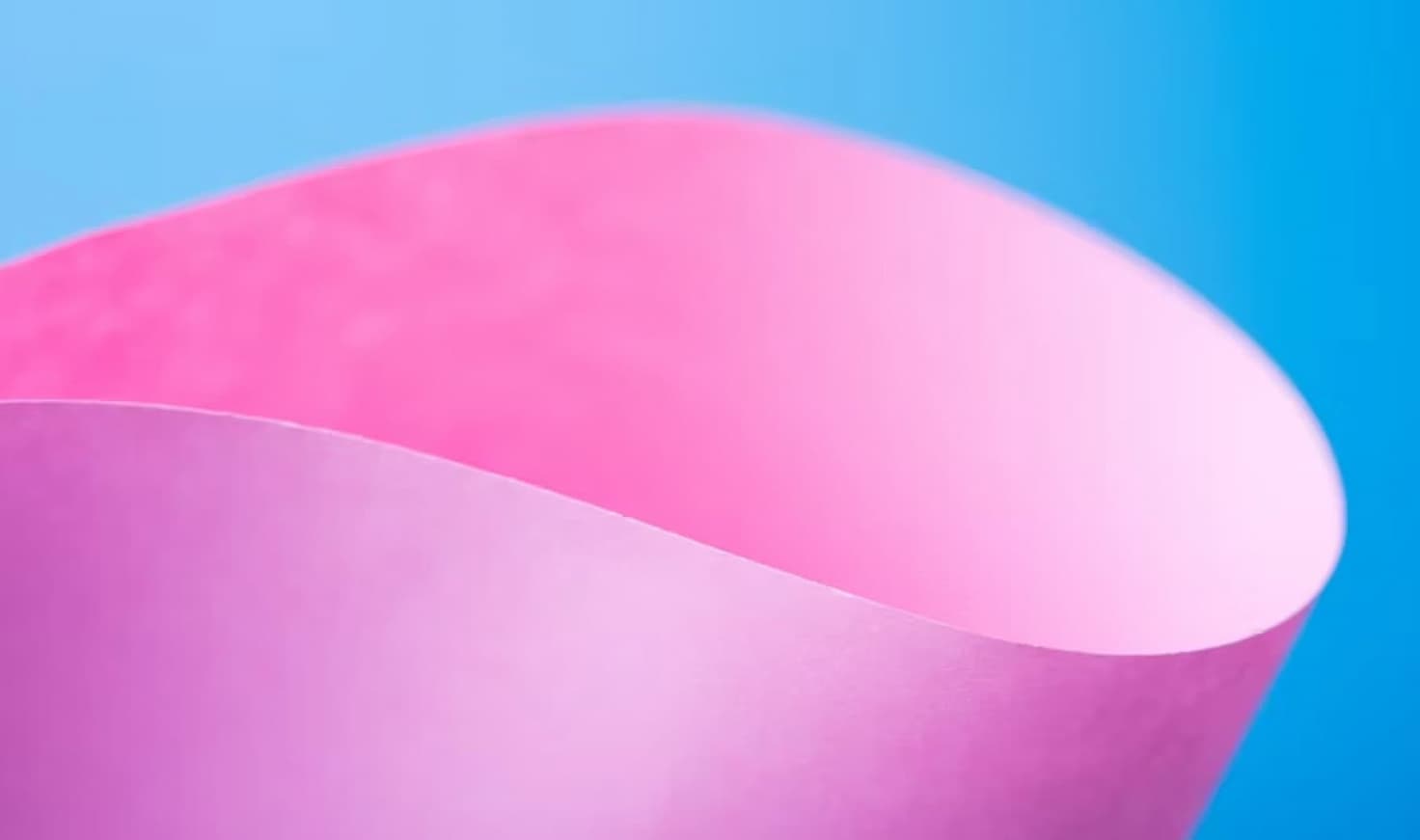 Papier plié rose sur fond bleu